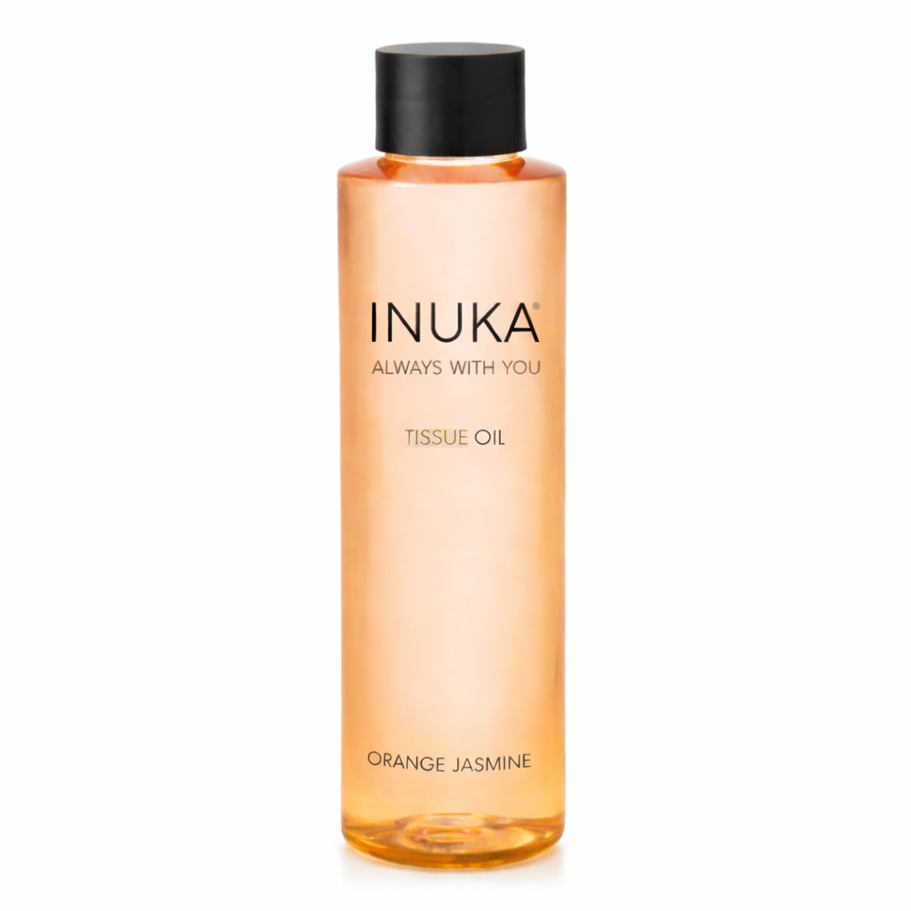 Inuka tissue oil bottle with orange liquid on a white background